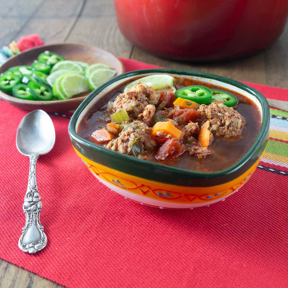 A photo of Mexican albondigas in a green and yellow bowl.